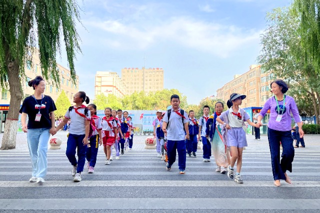 01 臨澤縣城關(guān)小學(xué)“紅燭先鋒”護學(xué)崗教師護送學(xué)生放學(xué)。謝靜 攝.jpg