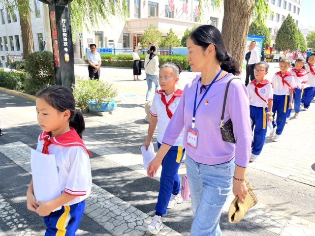 02 臨澤縣城關(guān)小學(xué)“紅燭先鋒”護學(xué)崗教師護送學(xué)生放學(xué)。謝靜 攝.jpg
