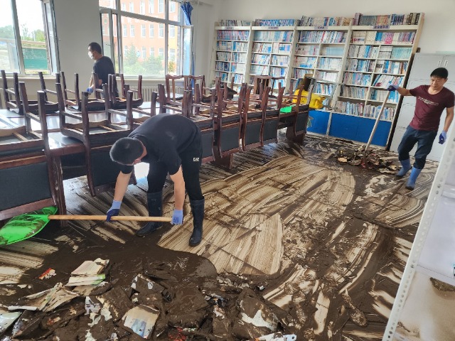 向陽鎮(zhèn)中心學校教師在清理淤泥。 李國彬 攝
