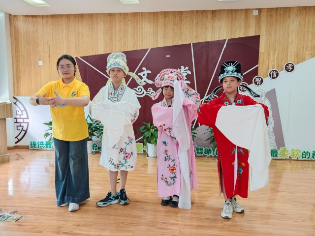 寧波職業(yè)技術(shù)大學“拾夢非遺”服務(wù)隊教小朋友們學唱傳統(tǒng)戲曲 學校供圖.jpg